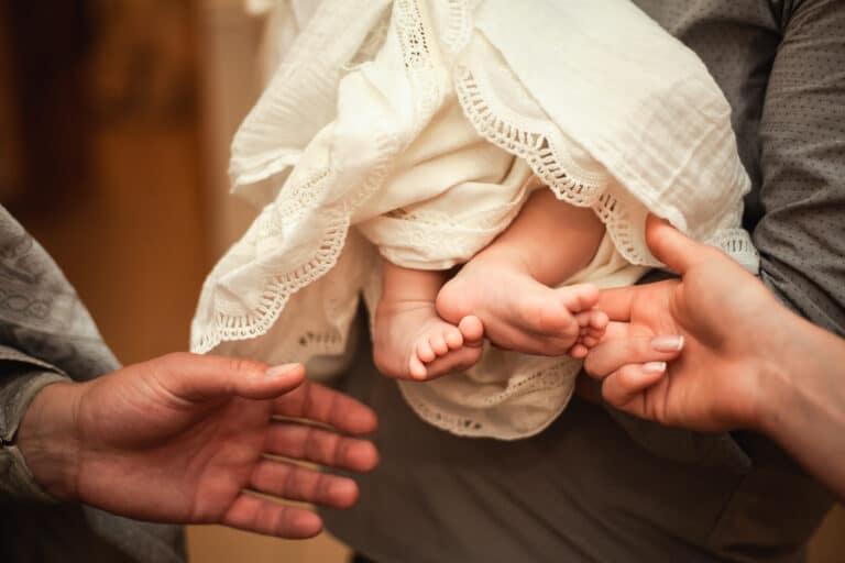 The baptism Of A Child. The Godfather Holds The Child.